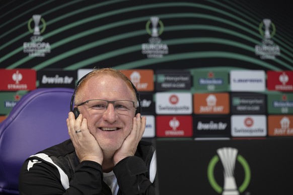 Basel&#039;s head coach Heiko Vogel laughs while listening to the translation on the headphones during a press conference the day before the UEFA Conference League semifinal first leg match between It ...