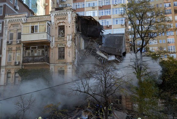 epa10248560 Rescuers work at the site of a drone explosion in downtown Kyiv (Kiev), Ukraine, 17 October 2022, amid the Russian invasion. Several residential buildings were damaged as a result of attac ...