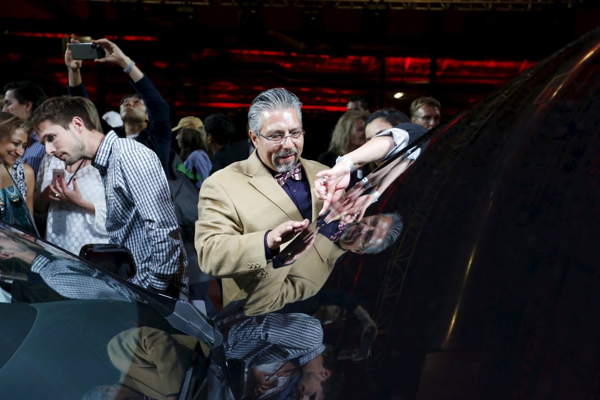 An attendee touches the hood of the new Tesla Motors Model X electric sports-utility vehicle after a presentation by CEO Elon Musk in Fremont, California September 29, 2015. Tesla Motors delivered the ...