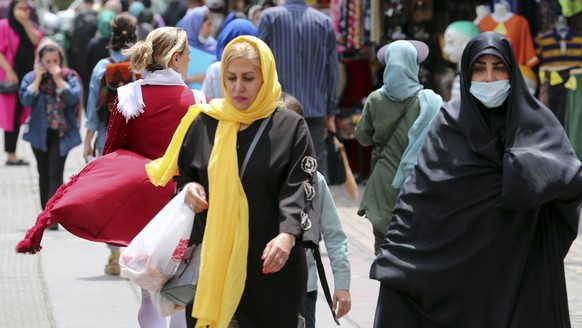 epa10646098 Iranian women, wearing a veil, walks among other pedestrians along a street in Tehran, Iran, 22 May 2023. Anti-government protests that erupted since the death in police custody of 22-year ...