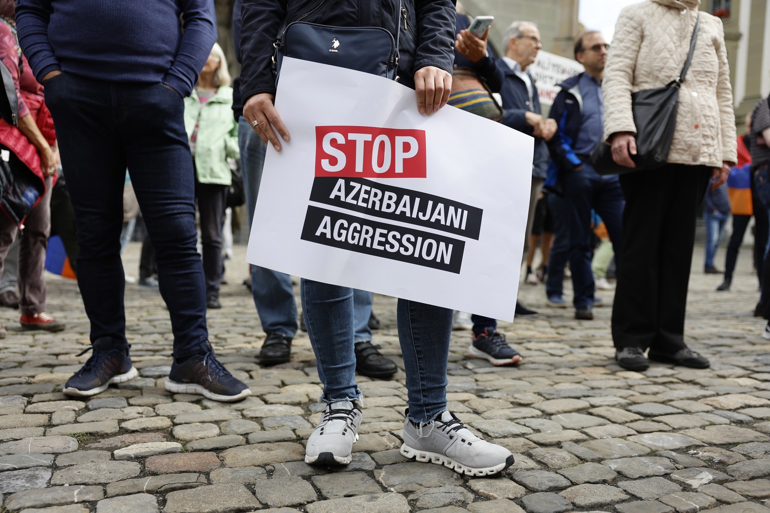 epa10878660 A protester holds a sign during a demonstration against Azerbaijan&#039;s military action in the Nagorno-Karabakh region in Bern, Switzerland, 23 September 2023. On 19 September 2023, Azer ...