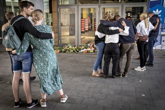 People pay their respects at the entrance of the Field&#039;s shopping center in Copenhagen, Denmark, Monday, July 4, 2022. Danish police believe a shopping mall shooting that left three people dead a ...