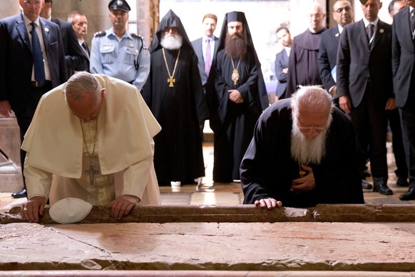 FILE - Pope Francis and Constantinople Patriarch Bartholomew kneel to kiss the Stone of Unction in the Church of the Holy Sepulchre, in Jerusalem, Israel, Sunday, May 25, 2014. (AP Photo/Andrew Medich ...