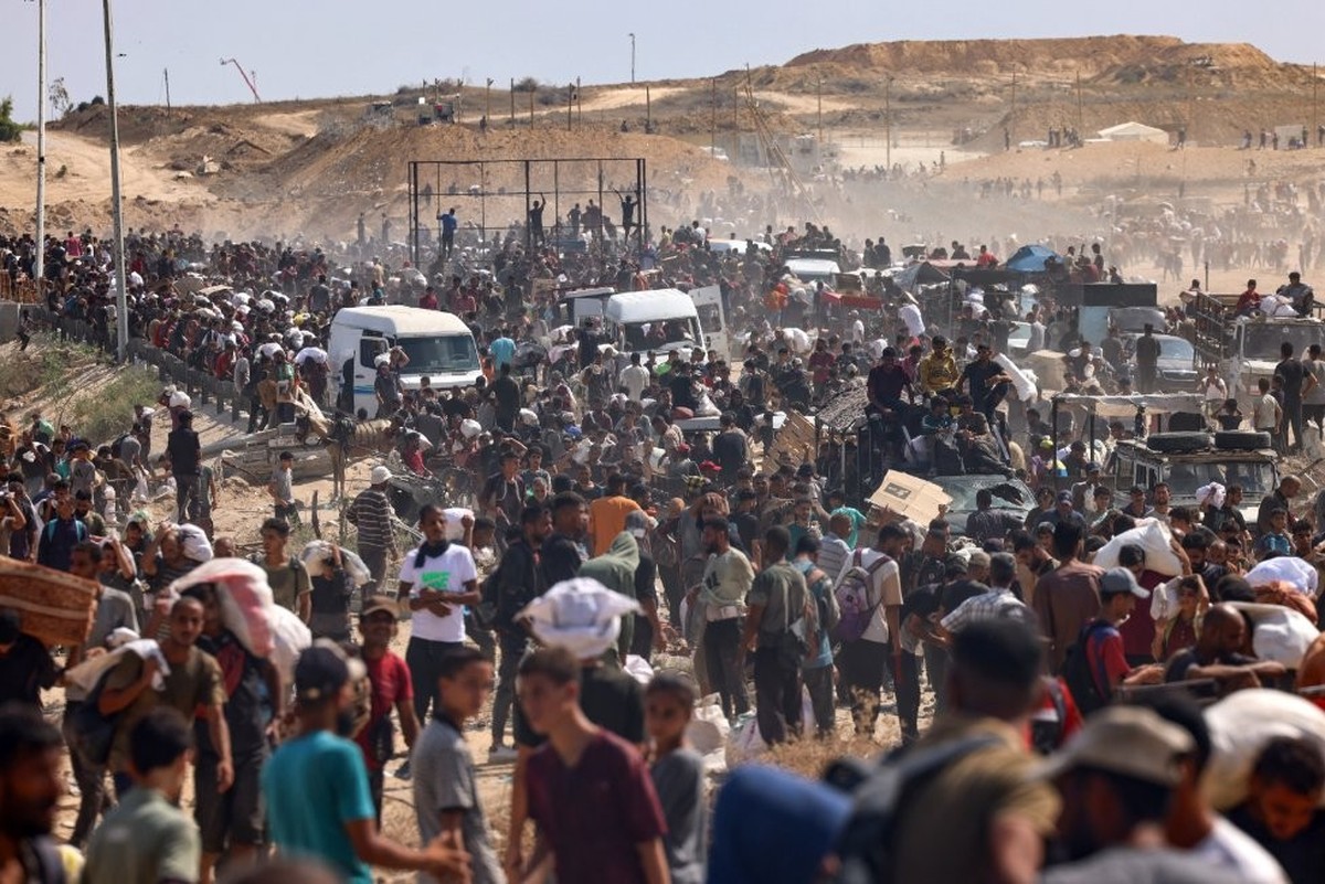 Des Palestiniens déplacés se rassemblent pour recevoir de l'aide dans un centre de distribution.