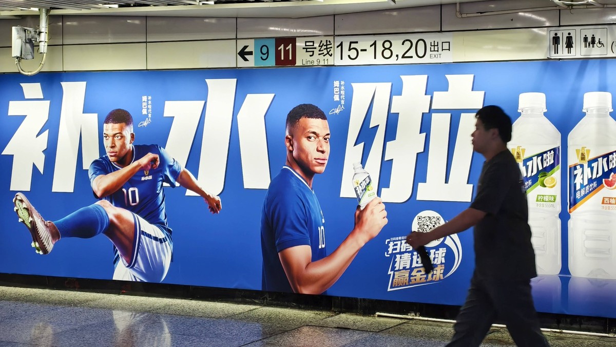 Shanghai, Chine, 30 juin 2026. Une publicité pour la boisson électrolytique Dongpeng, mettant en scène le footballeur français Kylian Mbappé, est affichée dans une station de métro. La marque a lancé  ...
