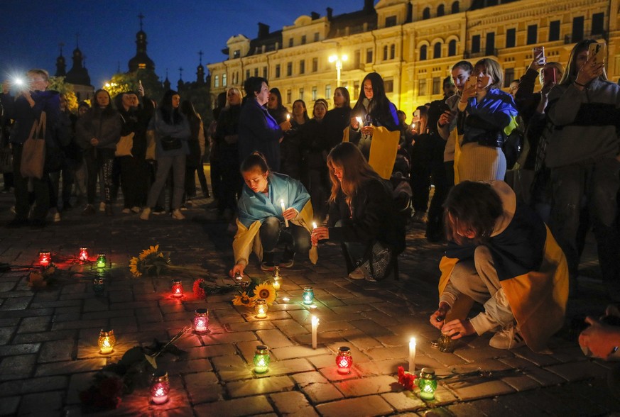 epa10166290 People lit candles as they take part in a rally organized by the 'Association of Families of Defenders of Azovstal', in memory of the Ukrainian prisoners of war (POW) killed in a blast at  ...