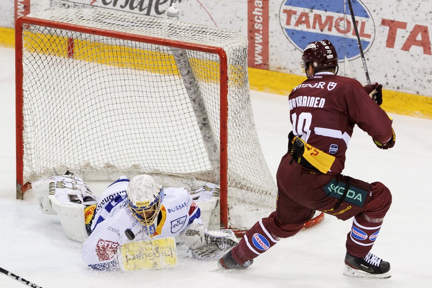 Zug&#039;s goaltender Leonardo Genoni, left, makes a big save past Geneve-Servette&#039;s forward Teemu Hartikainen, right, during a National League regular season game of the Swiss Championship betwe ...