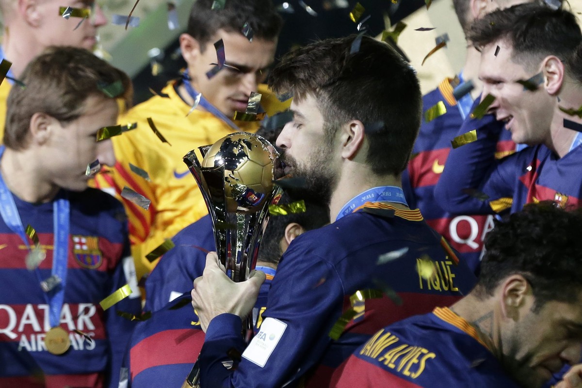 epa05076650 Barcelona's defender Gerard Pique kisses the trophy as he celebrates with teammates after winning the final match of the FIFA Club World Cup 2015 between FC Barcelona and River Plate  ...