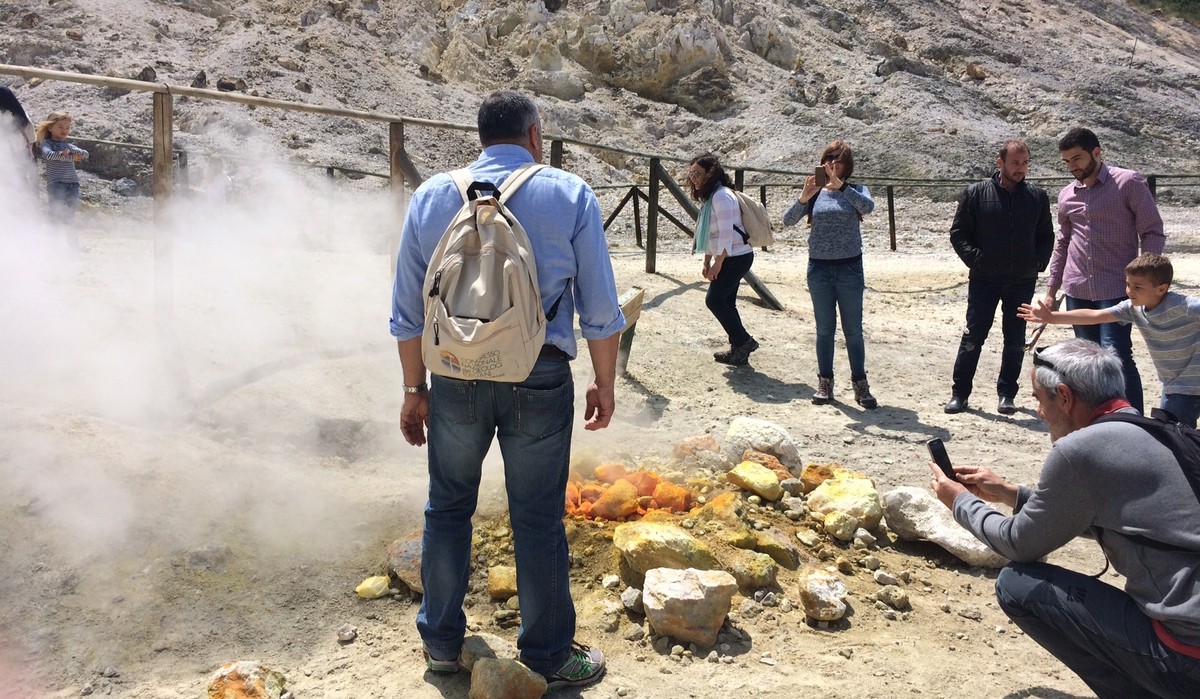 In this photo taken on Saturday, April 30, 2016, visitors look at steaming fumarolas at the Solfatara crater bed, in the Phlegraean Fields near Naples, Italy. Fields -- Campi Flegrei in Italian -- are ...