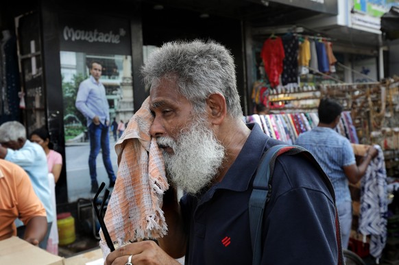 epa09884558 An Indian man uses his scarf to clean sweat off his face during a hot afternoon in Kolkata, Eastern India, 11 April 2022. The summer, or pre-monsoon season, occurs from March to July in ea ...