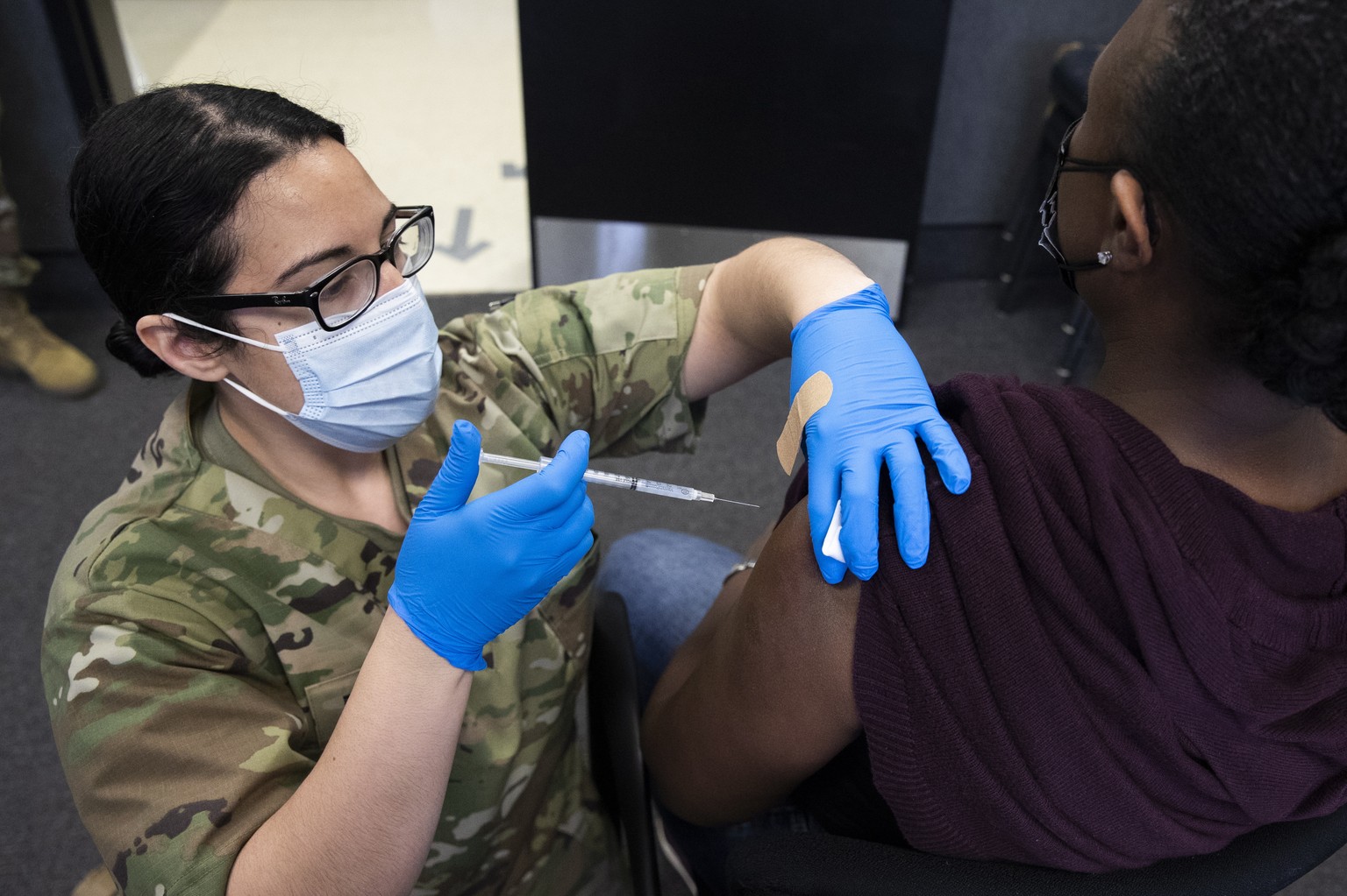 epa09110924 US Army First Lieutenant with the Maryland National Guard Medical Detachment, Kirsten Allen (L), administers a dose of the Moderna COVID-19 vaccine at Camp Fretterd Military Reservation, w ...