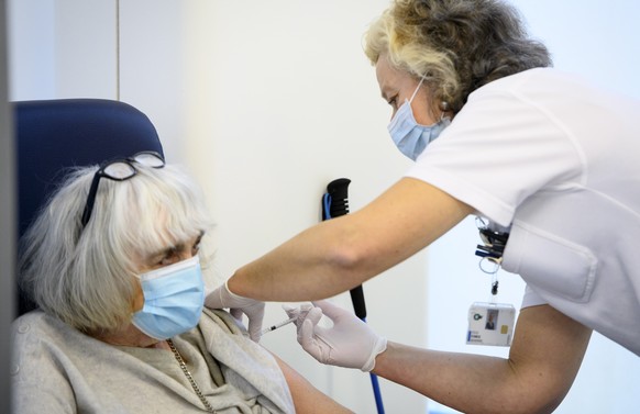 epa08931611 A nurse administers the Pfizer-BioNTech COVID-19 vaccine to Christiane Jaquet-Berger (L), president of Avivo, a Swiss association for the defense of the elderly, on the opening day of the  ...