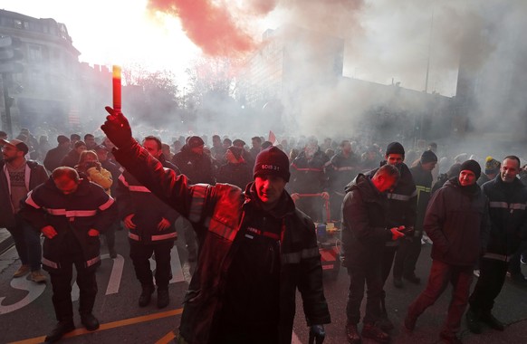 epa10415084 A firefighter lights a red torch during a national strike led by French trade unions against the government's reform of the pension system, in Toulouse, January 19, 2023. The French government...