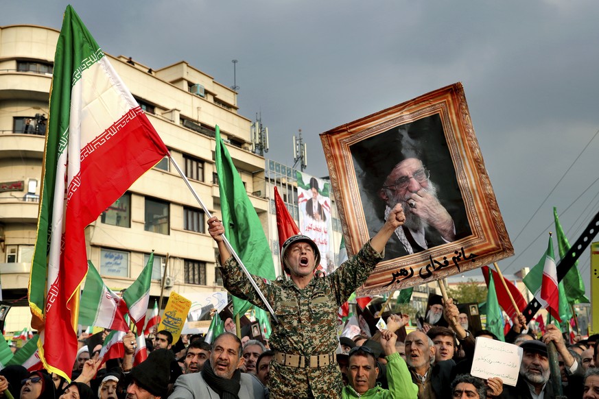 FILE - In a Nov. 25, 2019, file photo, a demonstrator chants slogans while holding up an Iranian national flag during a pro-government rally in Tehran, Iran, denouncing violent protests over a governm ...