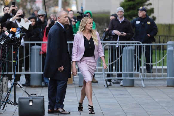 Porn actress Stormy Daniels, accompanied by her attorney, Michael Avenatti, left, leaves federal court, Monday, April 16, 2018 in New York. A U.S. judge listened to more arguments about President Dona ...