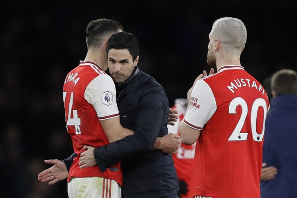 Arsenal&#039;s head coach Mikel Arteta, center congratulates Arsenal&#039;s Granit Xhaka, left, and Arsenal&#039;s Shkodran Mustafi end of the English Premier League soccer match between Arsenal and E ...