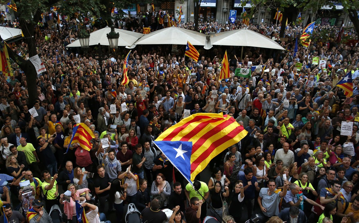 A crowd of protestors gather outside the Catalan region's economy ministry building in Barcelona, Spain, Wednesday, Sept. 20, 2017. The Catalan regional government says that a top official in the ...