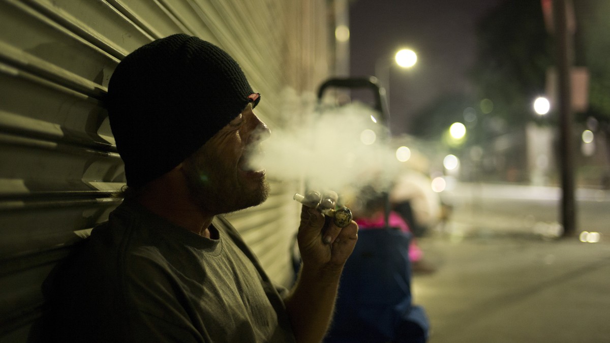D. J. Meek, a 40-year-old homeless drug addict, smokes crystal meth Friday, Sept. 8, 2017, in the Skid Row area of downtown Los Angeles. Meeks' veins are collapsed due to chronic use of heroin. H ...