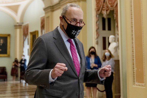 Senate Majority Leader Chuck Schumer of N.Y. walks off the Senate floor and pumps his fists as the Senate approves a $1 trillion bipartisan cornerstone of the Biden agenda to the House, on Capitol Hil ...