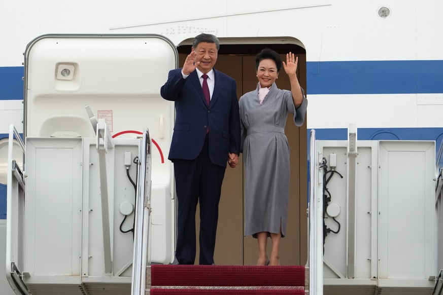 China's President Xi Jinping and his wife Peng Liyuan wave as they arrive at Joint Base Andrews, Md., Wednesday, Sept. 23, 2026, to be greeted by President Donald Trump and first lady Melania Tru ...