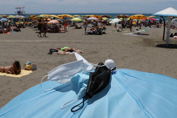 epa09302681 People relax and enjoy a sunny day at the beach, in Ostia, near Rome, Italy, 26 June 2021. From 28 June all the country will be considered as a 'white zone' with no mask obligation outdoor ...