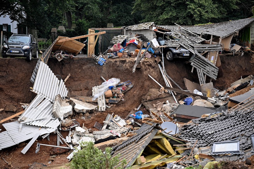 epa09348035 Residential houses and cars collapsed near a gravel pit in Erftstadt Blessem, Germany, 16 July 2021. Large parts of Western Germany were hit by heavy, continuous rain in the night to 15 Ju ...