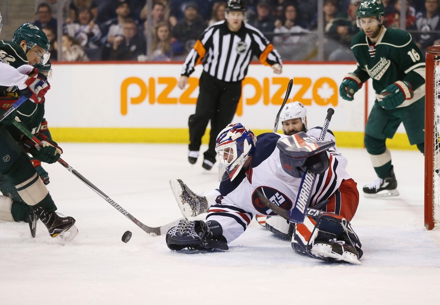 Mar 19, 2017; Winnipeg, Manitoba, CAN; Winnipeg Jets goalie Michael Hutchinson (34) looks to control a rebound on Minnesota Wild right wing Nino Niederreiter (22) during the third period at MTS Centre ...