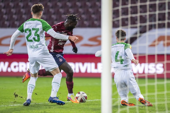 L&#039;attaquant genevois Grejohn Kyei, centre, lutte pour le ballon avec le milieu st-gallois Betim Fazliji, gauche, et le defenseur st-gallois Leonidas Stergiou, droite, lors de la rencontre de foot ...