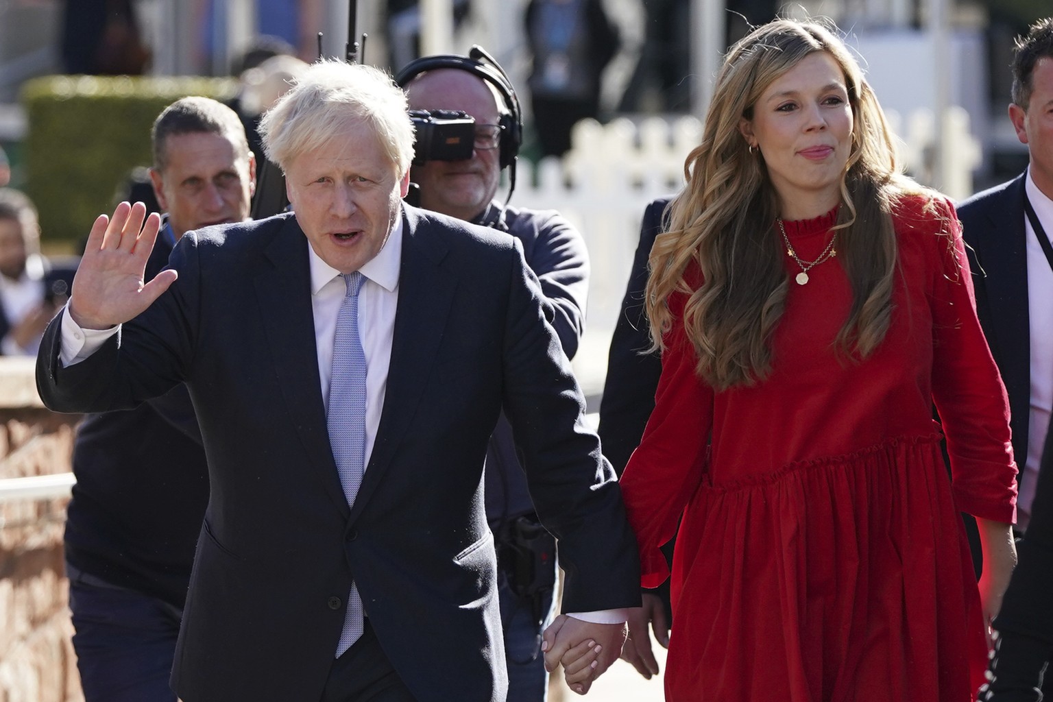 Britain&#039;s Prime Minister Boris Johnson waves to the media s he walks to the convention centre with his wife Carrie Johnson before he makes his keynote speech at the Conservative party conference  ...