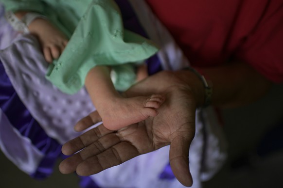 Nelida Lopez holds Peyton&#039;s foot, her newborn granddaughter, on the day Peyton arrived home from the hospital, in the Catia neighborhood of Caracas, Venezuela, Saturday, Sept. 12, 2020. The bigge ...
