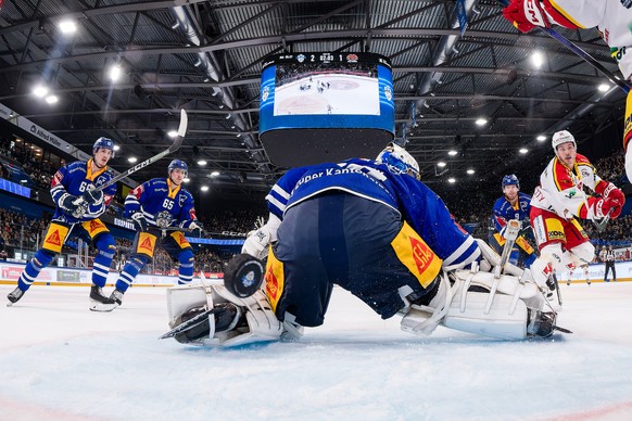 EHC Biels Tino Kessler, rechts, erzielt das Tor zum 2:2 gegen EV Zugs Torhueter Leonardo Genoni im Eishockey Qualifikationsspiel der National League zwischen dem EV Zug und dem EHC Biel-Bienne am Sams ...