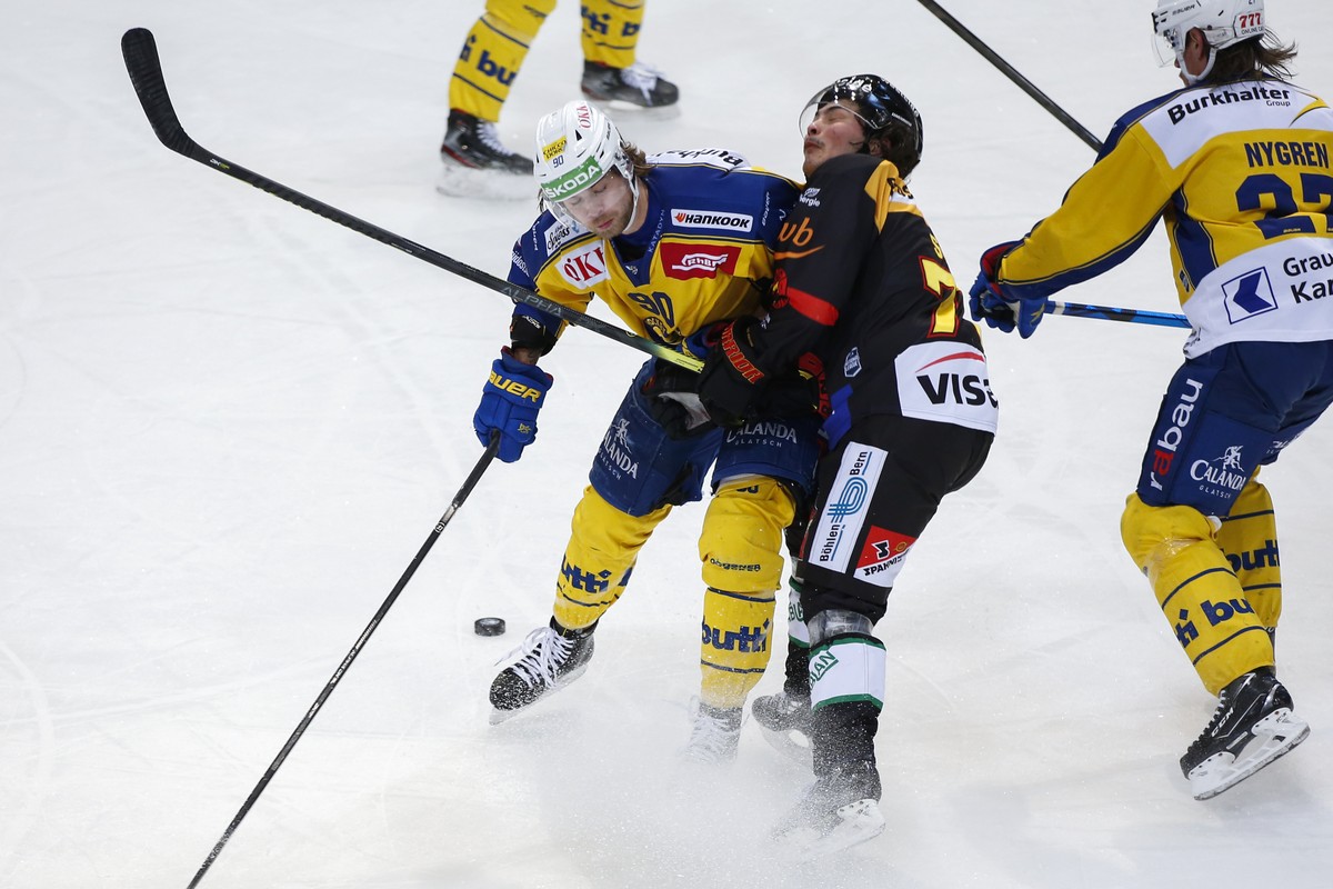 Davos' Sven Jung, links, checkt Berns Kyen Sopa, im Eishockey Meisterschaftsspiel der National League zwischen dem SC Bern und HC Davos, am Montag, 15. Februar 2021 in der Postfinance Arena in Be ...