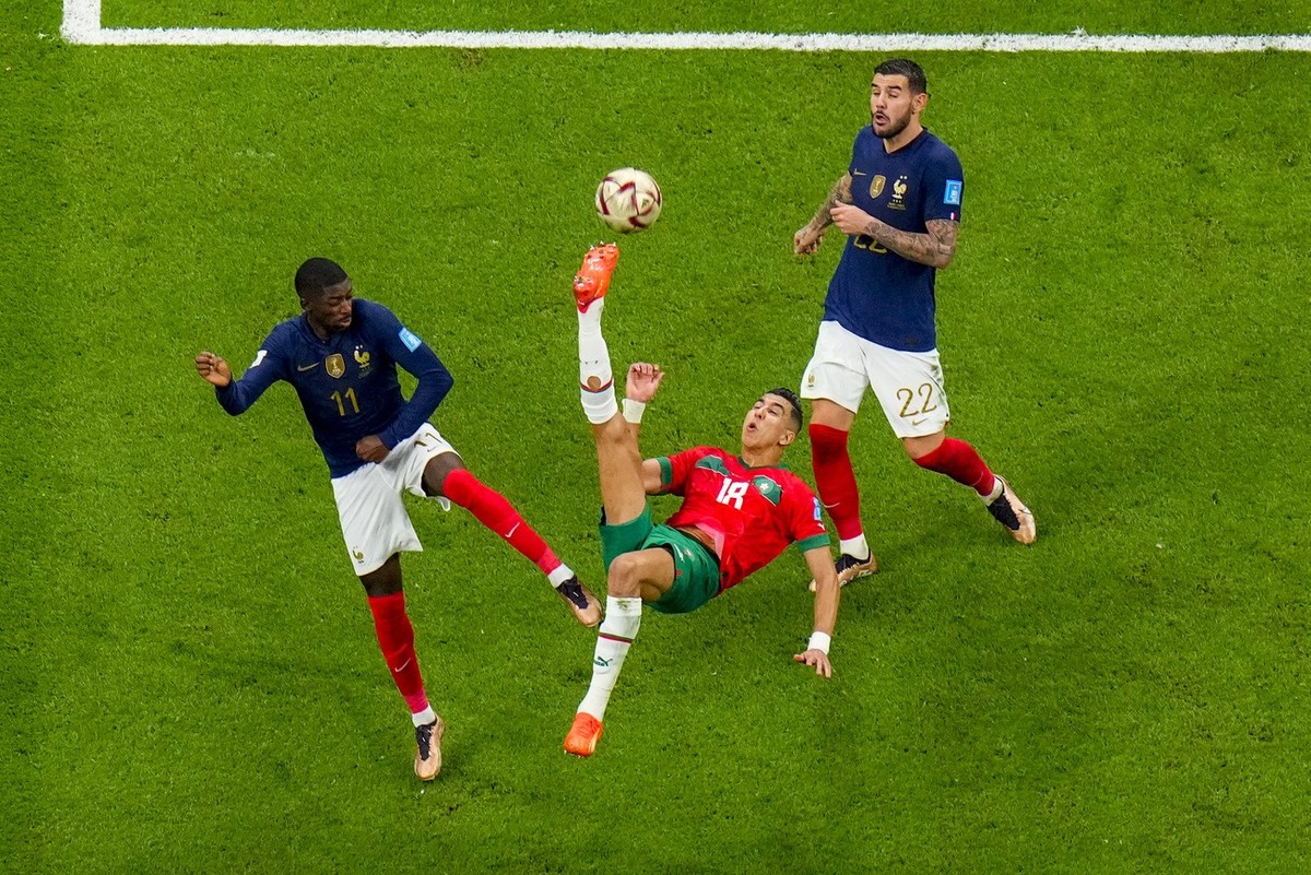 Morocco's Jawad El Yamiq, centre, attempts a shot at goal as France's Ousmane Dembele, left, and Theo Hernandez watch during the World Cup semifinal soccer match between France and Morocco a ...