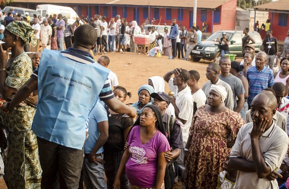 FILE- In this Wednesday, March 7, 2018 file photo, voters wait in line to cast their ballots during the first round of presidential election, outside a polling station in Freetown, Sierra Leone. Sierr ...