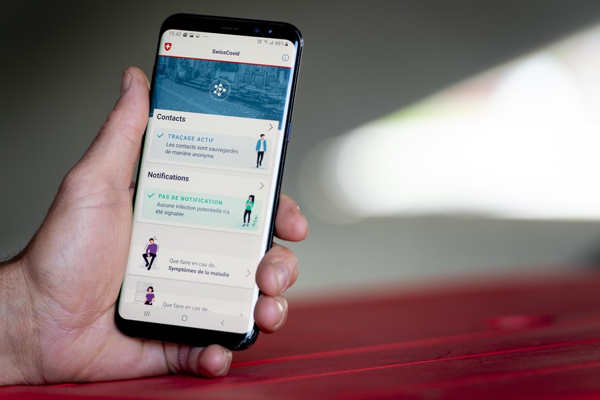 A man looking at a smartphone with the tracing app SwissCovid, using Decentralized Privacy-Preserving Proximity Tracing (DP-3T), during the state of emergency of the coronavirus disease (COVID-19) out ...