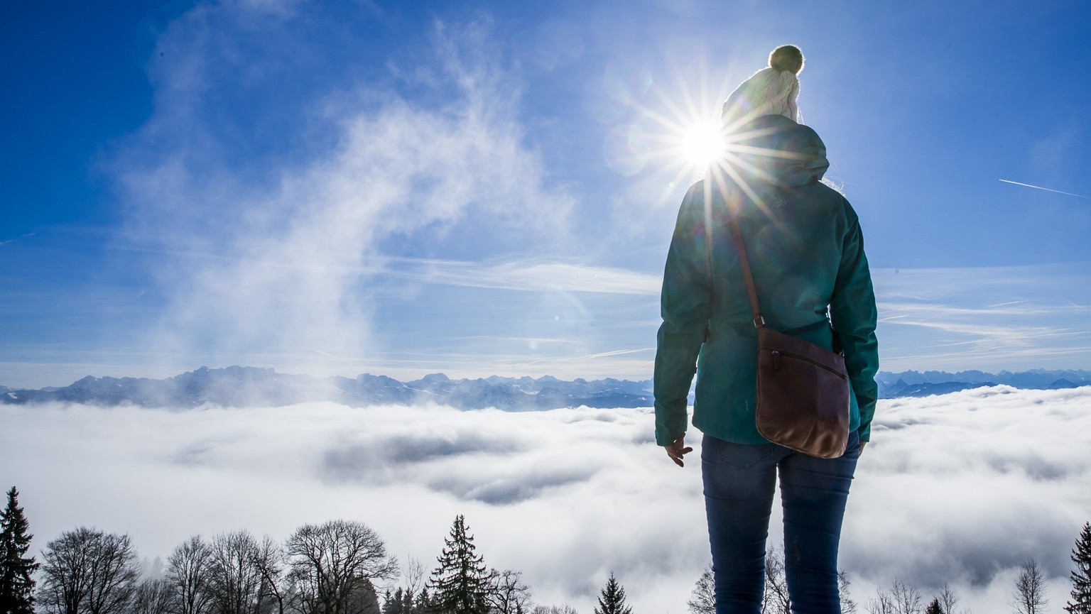 A woman enjoys the sun over the sea of fog on the Bachtel mountain, on Saturday, December 23, 2017, above Hinwil, Switzerland. (KEYSTONE/Christian Merz)..Eine Spaziergaengerin geniesst die Sonne ueber ...