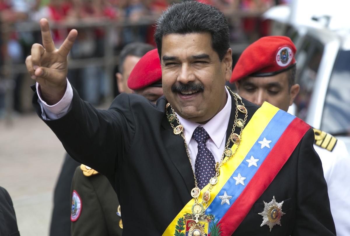 Venezuela's President Nicolas Maduro flashes a victory sign to supporters as he arrives to the Supreme Court to deliver his annual state of the nation report in Caracas, Venezuela, Sunday, Jan. 1 ...