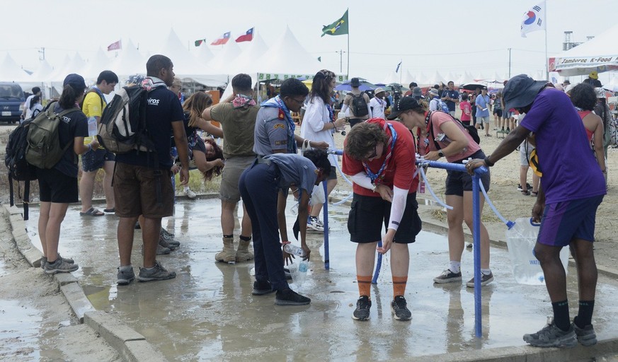 Attendees of the World Scout Jamboree cool off with water at a scout camping site in Buan, South Korea, Friday, Aug. 4, 2023. More than 4,000 British Scouts will leave the World Scout Jamboree at a ca ...
