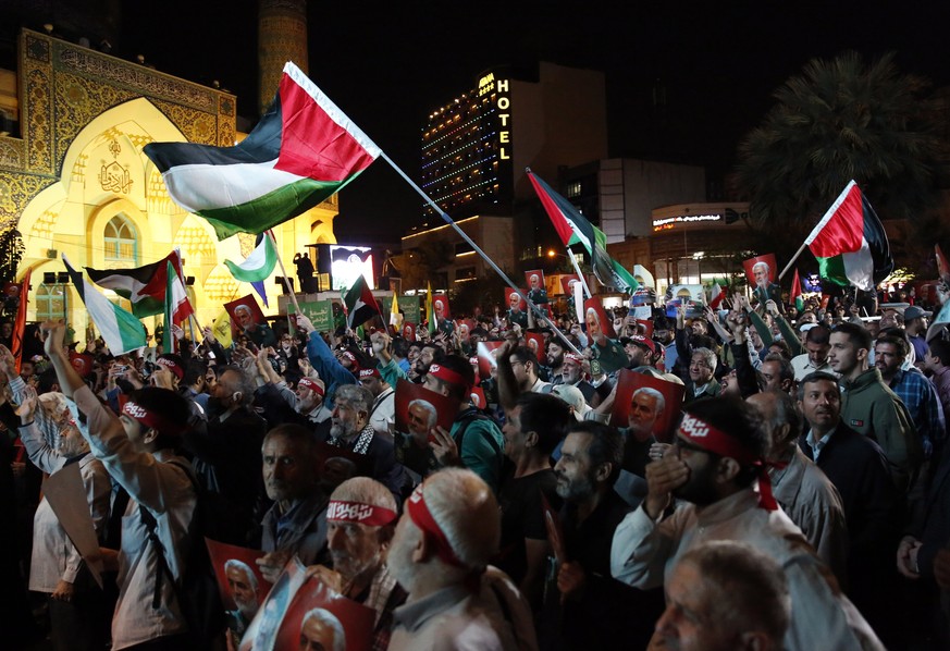 epa10906182 Iranian supporters of Hezbollah wave Palestinian flags during a celebration of the attacks that the militant Hamas group carried out against Israel and to express solidarity with Palestini ...