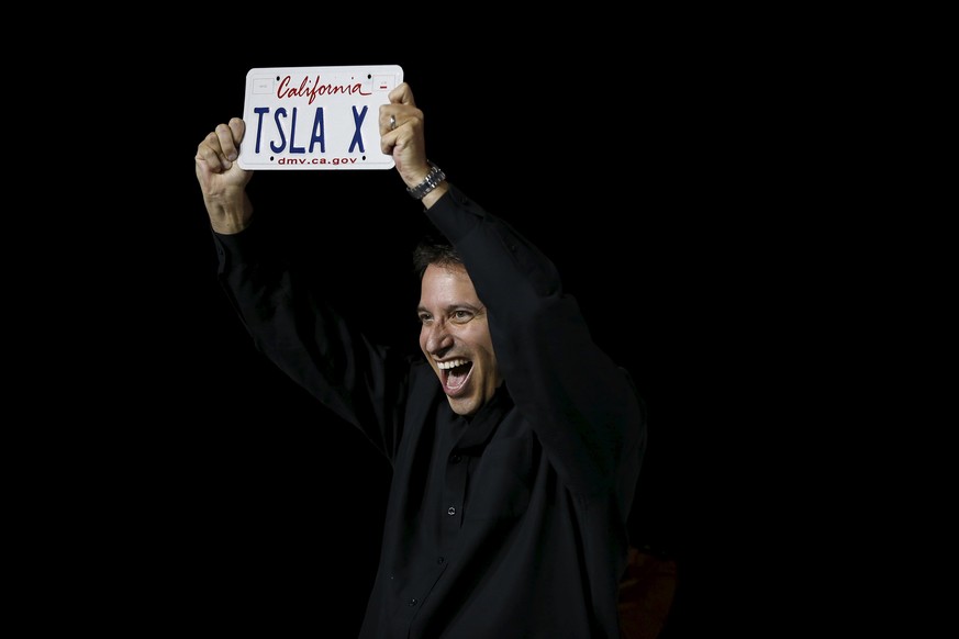 REFILE - CORRECTING TYPOAn attendee holds a license plate as CEO Elon Musk presented him the first Tesla Motors Model X electric sports-utility vehicle during a presentation in Fremont, California Sep ...