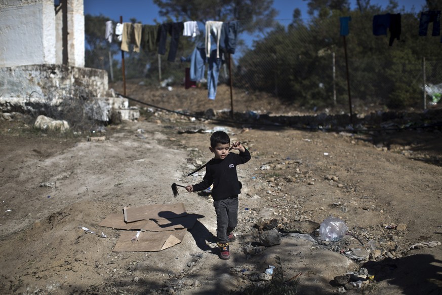 A child plays outside the migrant and refugee registration camp in Moria, on the island of Lesbos, Greece, Wednesday, Nov. 4, 2015. Dozens of overcrowded inflatable dinghies and wooden boats reach Gre ...