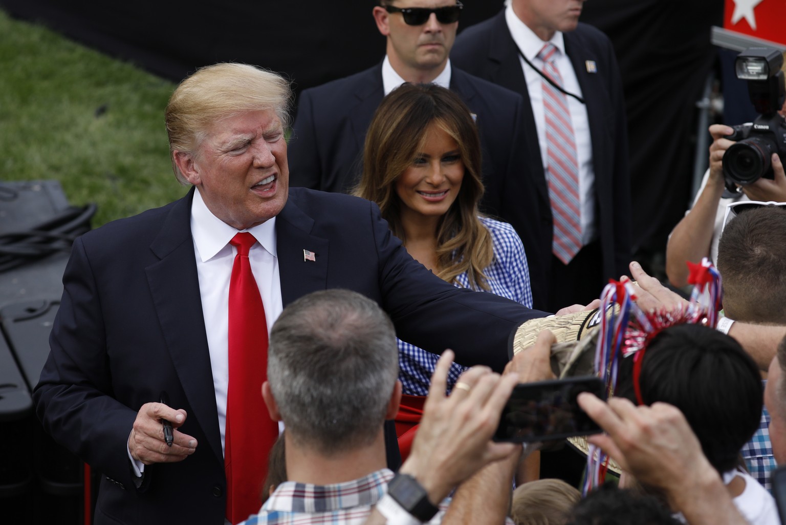 epa06864711 US President Donald J. Trump (L) and First Lady Melania Trump (2nd L) greet guests as they hold a picnic for military families at the White House, in Washington, DC, USA, on 04 July 2018.  ...