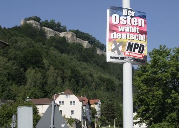 Ein Wahlplakat der NPD haengt am Dienstag, 10. Juni 2008, an einer Strasse in Koenigstein, Landkreis Saechsische Schweiz. Im Hintergrund die Festung Koenigstein. Die CDU hat die Kommunalwahlen in Sach ...