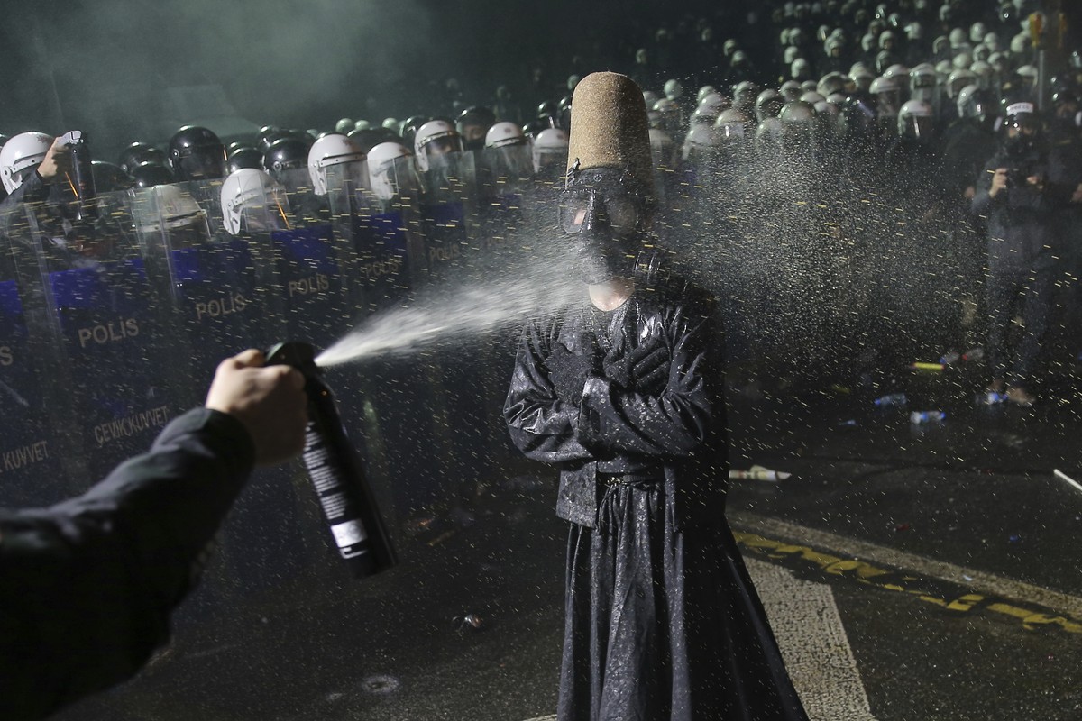 Riot police officers use pepper spray to clear a protester during a protest after Istanbul's Mayor Ekrem Imamoglu was arrested and sent to prison, in Istanbul, Turkey, Sunday, March 23, 2025. (AP ...