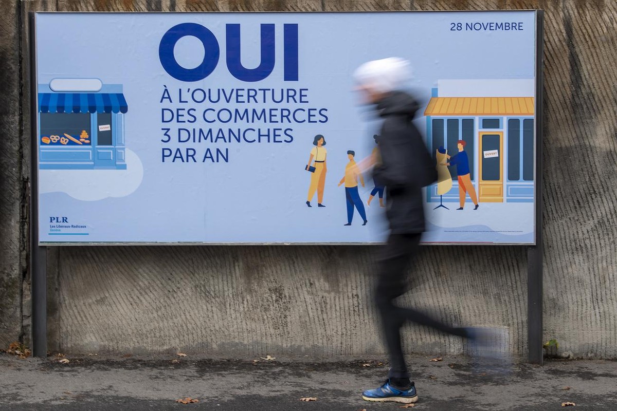 Une personne passe devant une affiche du PLR donnant son mots d'ordre pour la votation cantonale du 28 novembre, les citoyens genevois se prononceront sur l'un des trois objets cantonaux gen ...