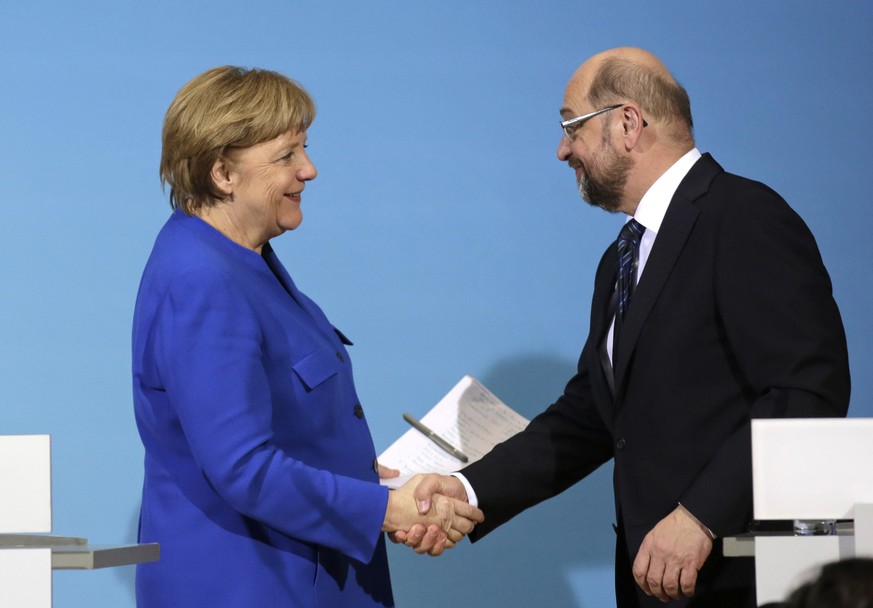 FILE - In this Jan. 12, 2018 file photo German Chancellor Angela Merkel, left, shakes hand with Social Democratic Party Chairman Martin Schulz during a joint statement after the exploratory talks betw ...