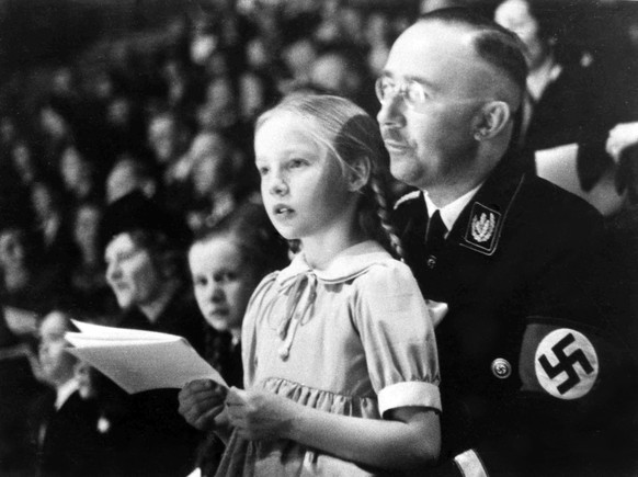 FILE - In this March 6, 1938 file photo Chief of the German Police and Minister of the Interior Heinrich Himmler, with his daughter Gudrun on his lap, watch an indoor sports display in Berlin. Germany ...