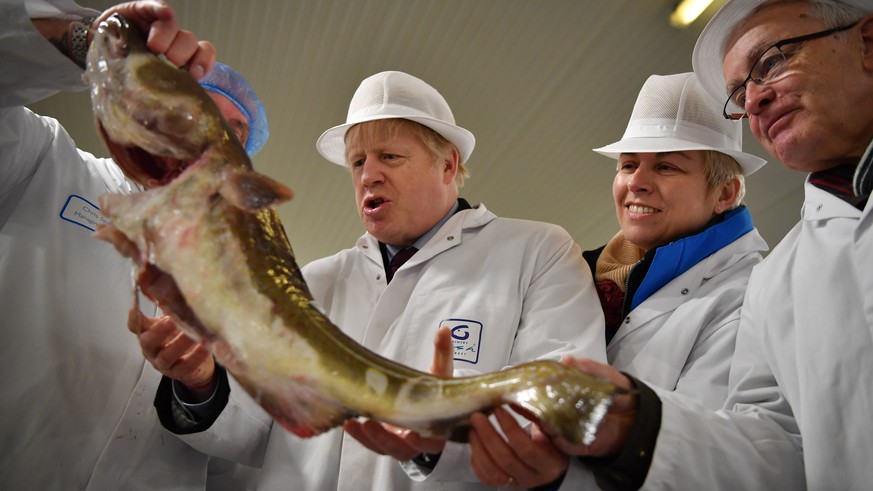 FILE - In this Dec. 9, 2020 file photo, Britain&#039;s Prime Minister and Conservative Party leader Boris Johnson, center, visits Grimsby fish market in Grimsby, northeast England. On the eve of a Eur ...