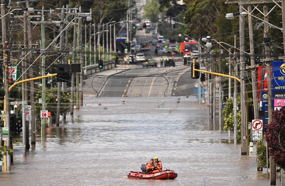 epa10242588 SES personal are seen searching floodwaters along Raleigh street in Maribyrnong, Melbourne, Australia, 14 October 2022. Victorian residents have been told to move to higher ground as rain  ...