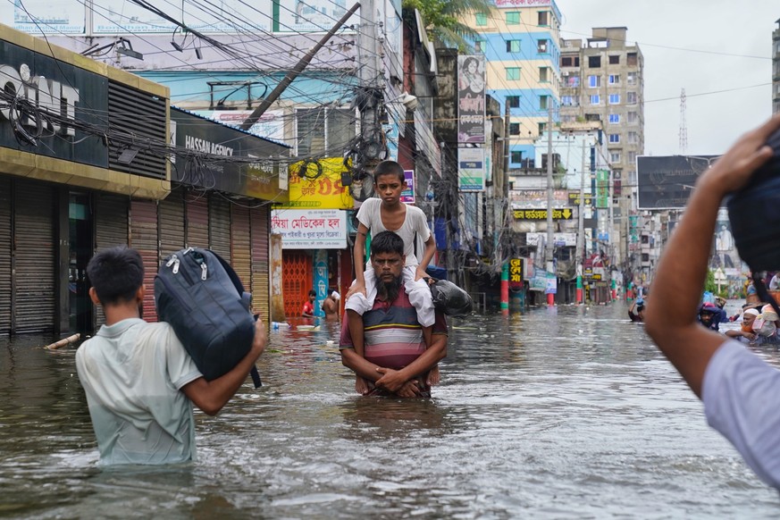A father carrying his son through the flood water, in Feni. 

Catastrophic floods in southeastern Bangladesh, particularly in Noakhali, Feni, and Khagrachari, are wreaking havoc, in August 2024. 

Ove ...